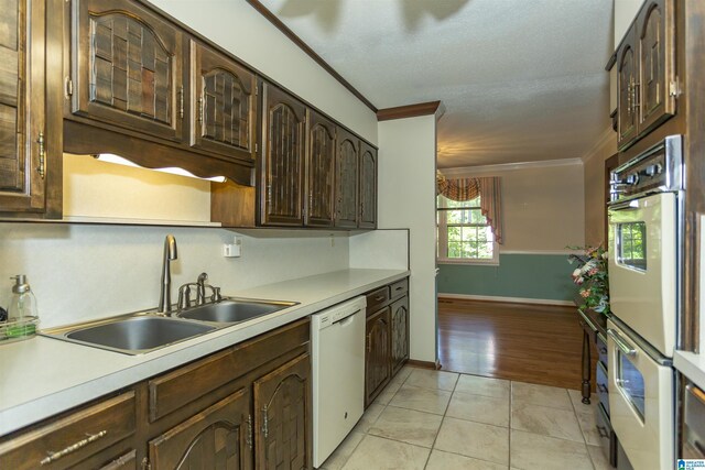 3300 Shetland Trce, Birmingham, AL 35242 - kitchen featuring white appliances, ornamental molding, a sink, light countertops, and dark brown cabinetry