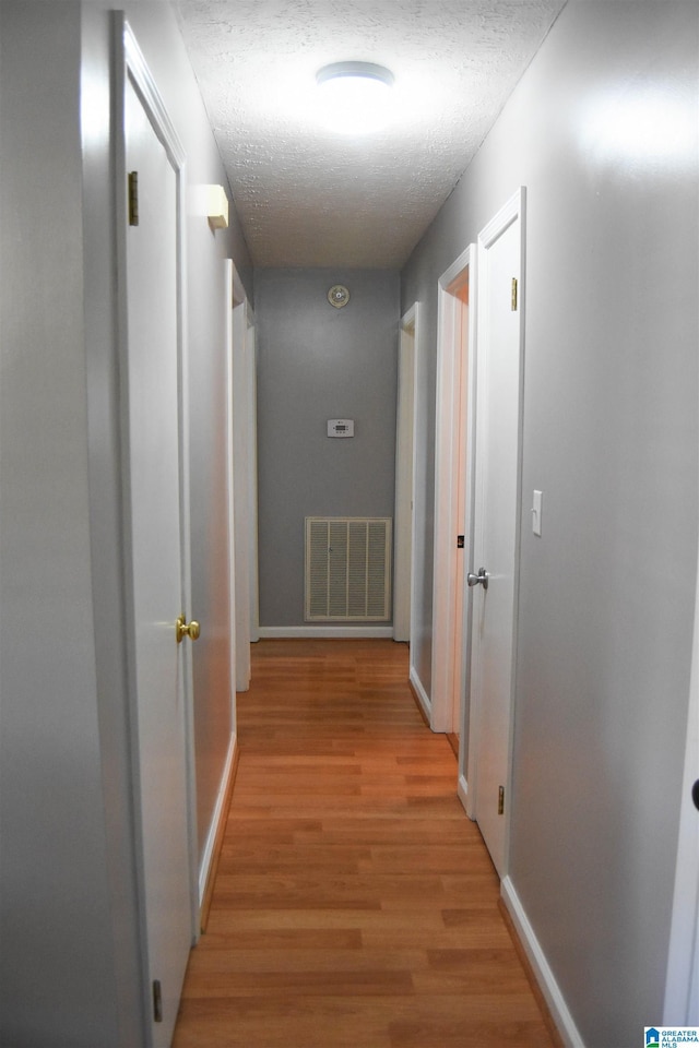 1508 Cloverdale Rd, Anniston, AL 36207 - hallway with light wood finished floors, a textured ceiling, and baseboards