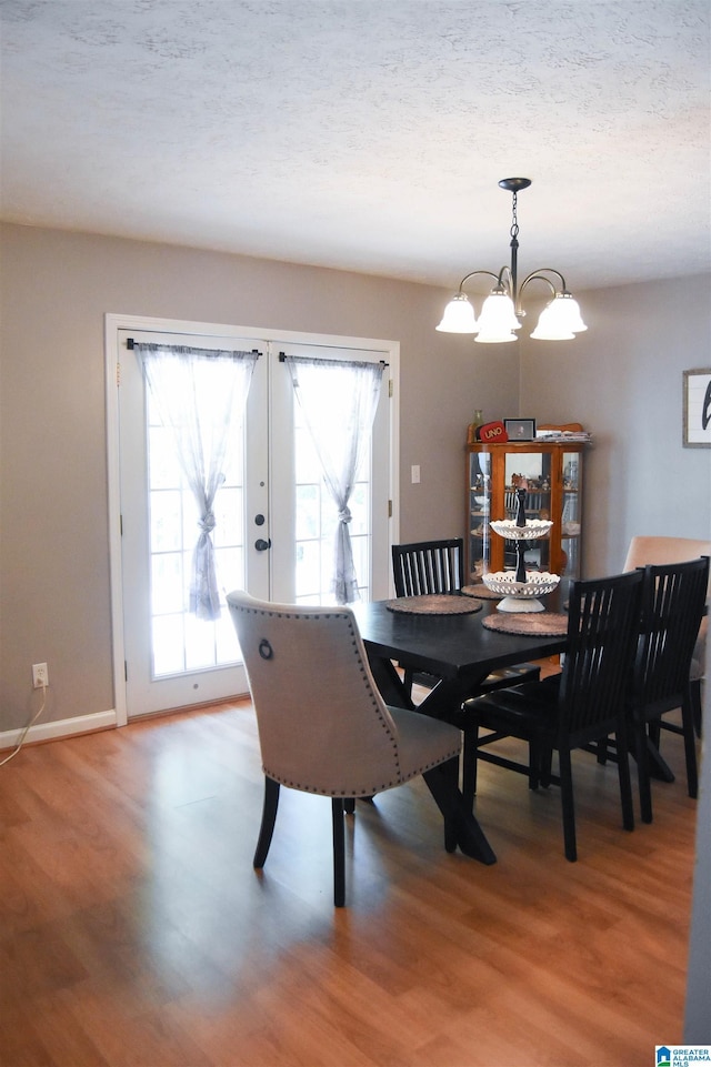1508 Cloverdale Rd, Anniston, AL 36207 - dining space with light wood-type flooring, a chandelier, baseboards, french doors, and a textured ceiling