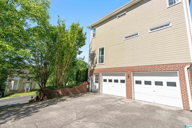 1709 Wakefield Dr, Hoover, AL 35216 - view of side of home featuring an attached garage, brick siding, and driveway