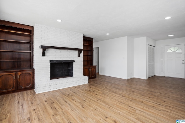 1826 Edwardian Way, Anniston, AL 36207 - unfurnished living room featuring wood finished floors, recessed lighting, baseboards, and a brick fireplace