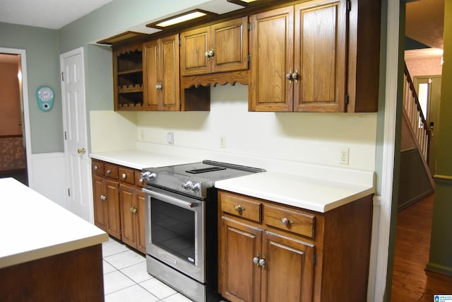 2301 Hathaway Heights Rd, Anniston, AL 36207 - kitchen featuring stainless steel range with electric cooktop, brown cabinets, light countertops, and open shelves