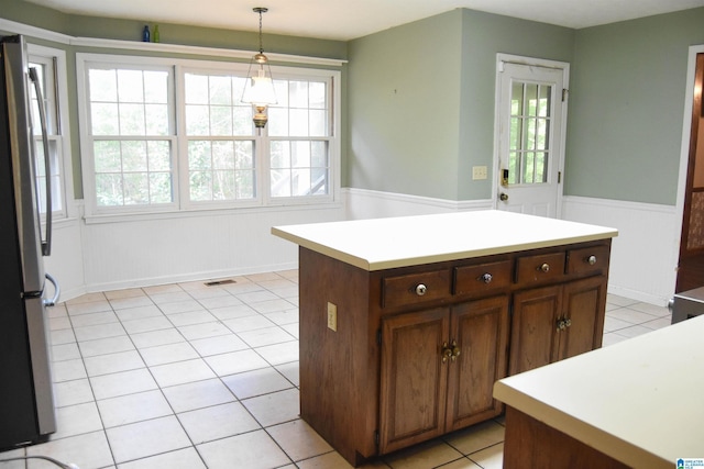 2301 Hathaway Heights Rd, Anniston, AL 36207 - kitchen with a wainscoted wall, hanging light fixtures, light countertops, light tile patterned floors, and freestanding refrigerator