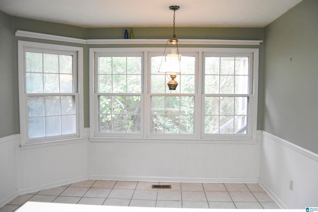 2301 Hathaway Heights Rd, Anniston, AL 36207 - unfurnished dining area featuring a wainscoted wall, plenty of natural light, and light tile patterned floors