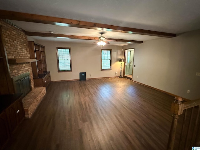 2301 Hathaway Heights Rd, Anniston, AL 36207 - unfurnished living room with dark wood-style flooring, beam ceiling, a brick fireplace, baseboards, and a ceiling fan