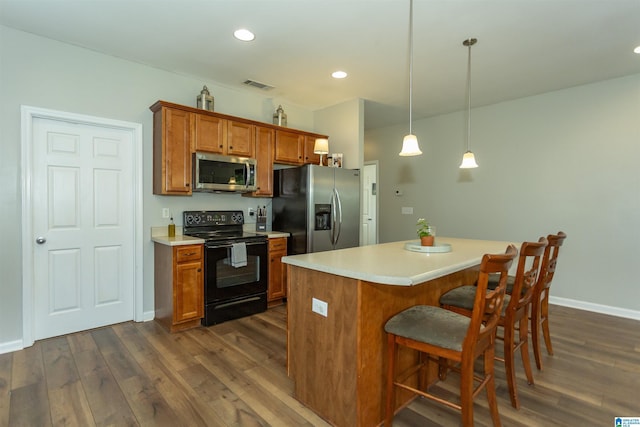 1009 Fairbank Ln, Chelsea, AL 35043 - kitchen with stainless steel appliances, brown cabinets, dark wood finished floors, a kitchen bar, and light countertops