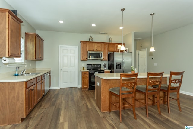 1009 Fairbank Ln, Chelsea, AL 35043 - kitchen featuring stainless steel appliances, dark wood finished floors, brown cabinetry, a kitchen breakfast bar, and recessed lighting