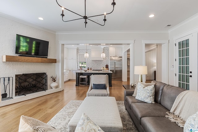 3 Troon, Birmingham, AL 35242 - living area featuring crown molding, light wood finished floors, a chandelier, recessed lighting, and a brick fireplace