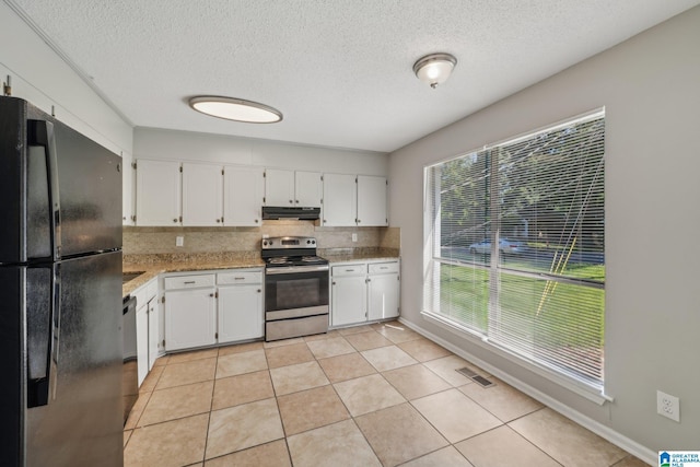 1056 Cardinal Cir, Hueytown, AL 35023 - kitchen with freestanding refrigerator, stainless steel electric range oven, range hood, tasteful backsplash, and a textured ceiling