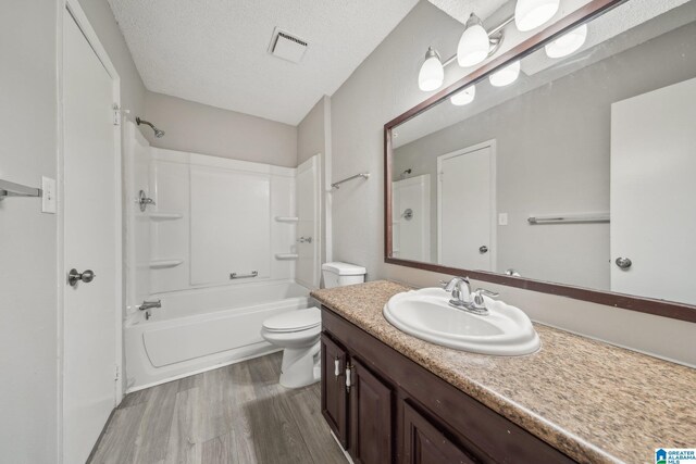 1056 Cardinal Cir, Hueytown, AL 35023 - full bath featuring toilet, wood finished floors, vanity,  shower combination, and a textured ceiling