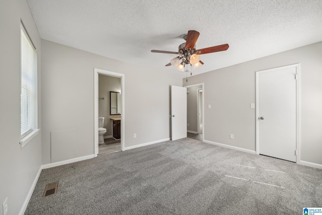 1056 Cardinal Cir, Hueytown, AL 35023 - unfurnished bedroom with carpet flooring, a textured ceiling, baseboards, ensuite bath, and a ceiling fan