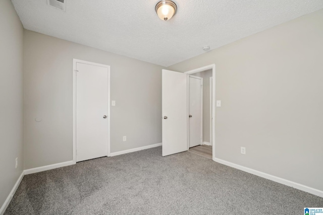 1056 Cardinal Cir, Hueytown, AL 35023 - unfurnished bedroom with carpet floors, baseboards, and a textured ceiling