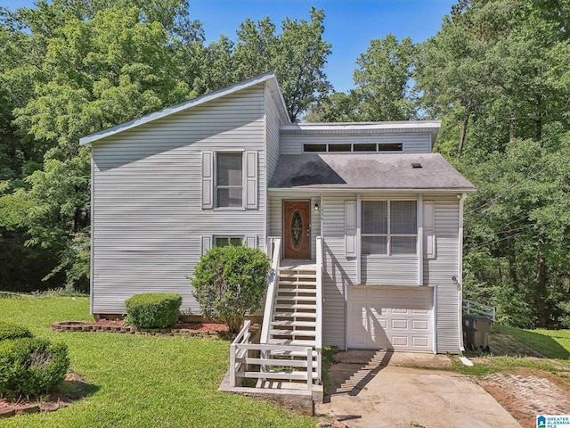 1056 Cardinal Cir, Hueytown, AL 35023 - tri-level home featuring driveway, an attached garage, a front yard, stairs, and roof with shingles