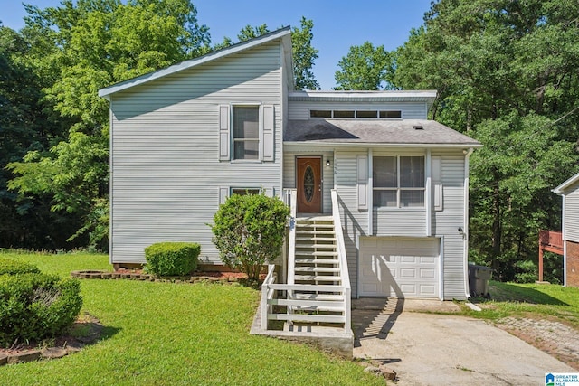 1056 Cardinal Cir, Hueytown, AL 35023 - tri-level home with concrete driveway, a garage, and a front lawn