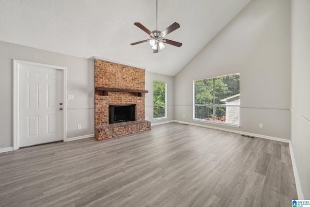 1056 Cardinal Cir, Hueytown, AL 35023 - unfurnished living room featuring ceiling fan, high vaulted ceiling, wood finished floors, baseboards, and a brick fireplace