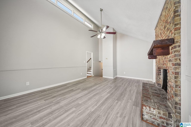 1056 Cardinal Cir, Hueytown, AL 35023 - unfurnished living room featuring a fireplace, wood finished floors, a ceiling fan, baseboards, and stairway