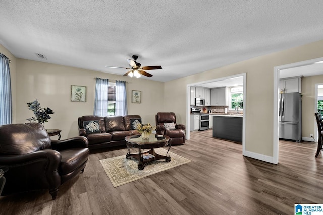 14 County Road 279, Cullman, AL 35057 - living room with wood finished floors, a textured ceiling, a ceiling fan, and baseboards