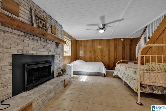 14 County Road 279, Cullman, AL 35057 - bedroom with light tile patterned flooring, wood walls, a fireplace, and a ceiling fan