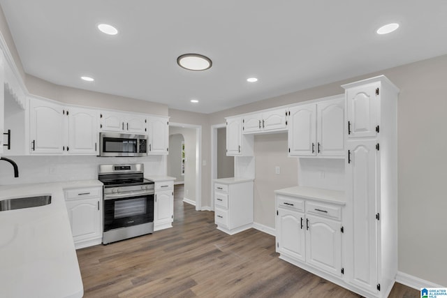 7300 6th Ave S, Birmingham, AL 35206 - kitchen with stainless steel appliances, a sink, baseboards, wood finished floors, and recessed lighting