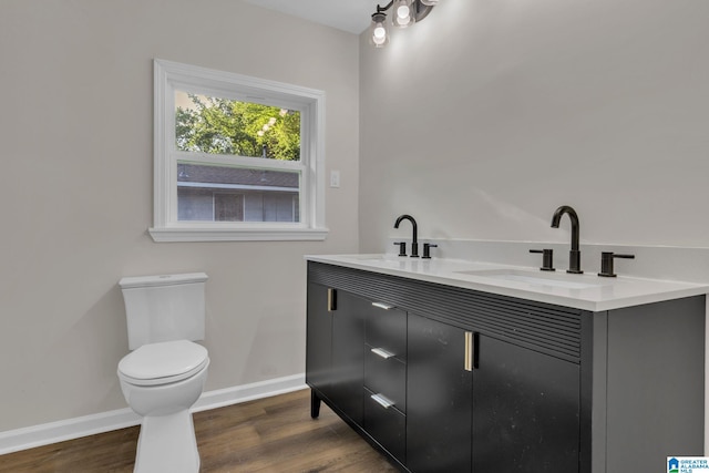 7300 6th Ave S, Birmingham, AL 35206 - bathroom with baseboards, toilet, wood finished floors, and double vanity