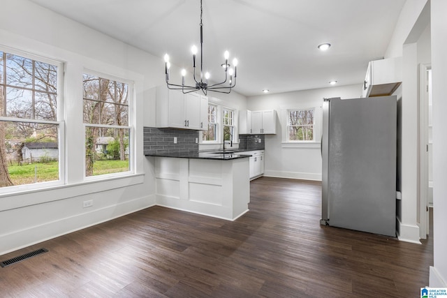 3010 15th St, Ensley, Birmingham, AL 35208 - kitchen featuring freestanding refrigerator, a chandelier, a peninsula, dark countertops, and white cabinetry