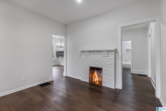 3010 15th St, Ensley, Birmingham, AL 35208 - unfurnished living room featuring wood finished floors, a chandelier, a fireplace, and baseboards