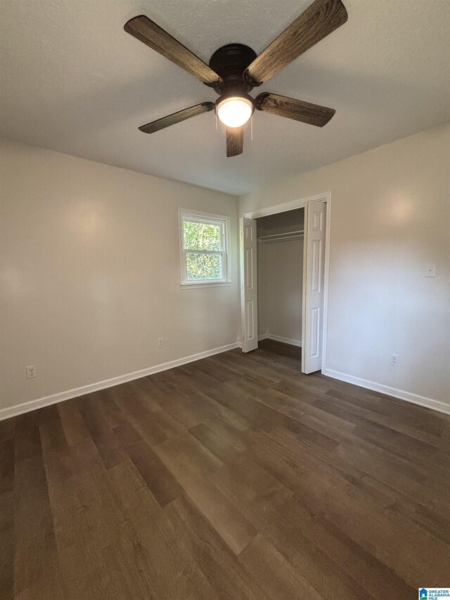 913 Alexandria Rd, Weaver, AL 36277 - unfurnished bedroom with dark wood-type flooring, baseboards, a closet, and a ceiling fan