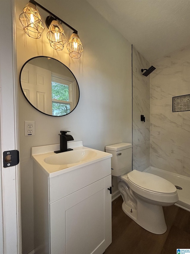 913 Alexandria Rd, Weaver, AL 36277 - full bath with toilet, vanity, wood finished floors, a tile shower, and baseboards
