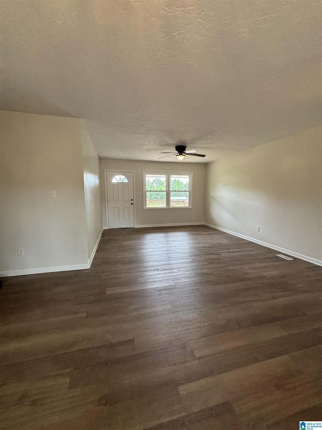 913 Alexandria Rd, Weaver, AL 36277 - unfurnished living room with ceiling fan, dark wood-style flooring, baseboards, and a textured ceiling