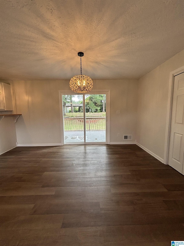 913 Alexandria Rd, Weaver, AL 36277 - unfurnished dining area with a textured ceiling, a chandelier, baseboards, and dark wood finished floors