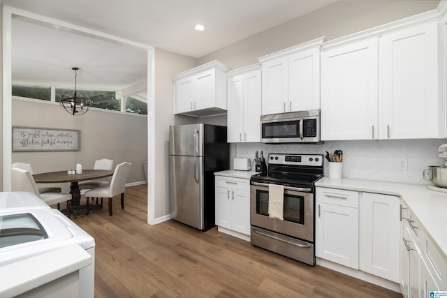 1345 Cresthill Rd, Birmingham, AL 35213 - kitchen featuring appliances with stainless steel finishes, a chandelier, decorative backsplash, light countertops, and white cabinets