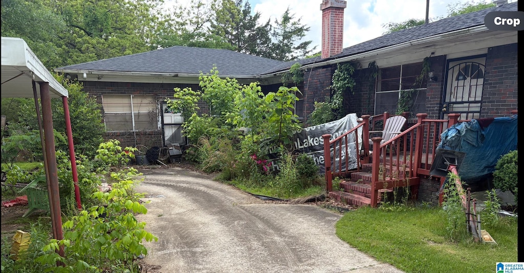 1193 7th St SE, Graysville, AL 35073 - view of front of property featuring brick siding, a chimney, roof with shingles, and driveway