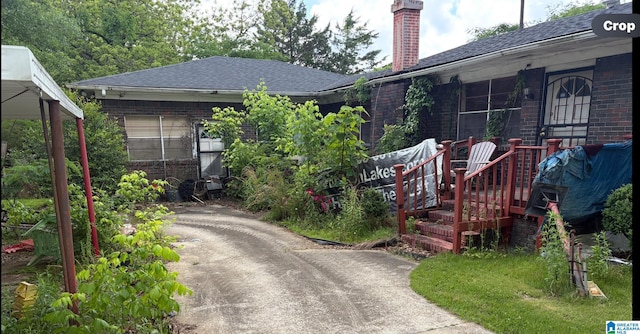 1193 7th St SE, Graysville, AL 35073 - view of front of property featuring brick siding, a chimney, roof with shingles, and driveway
