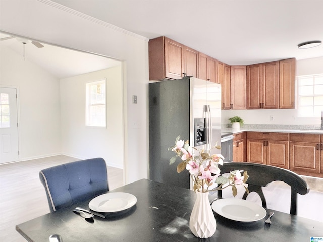 2723 6th St NE, Center Point, AL 35215 - kitchen featuring stainless steel refrigerator with ice dispenser, light wood-style flooring, brown cabinets, and vaulted ceiling