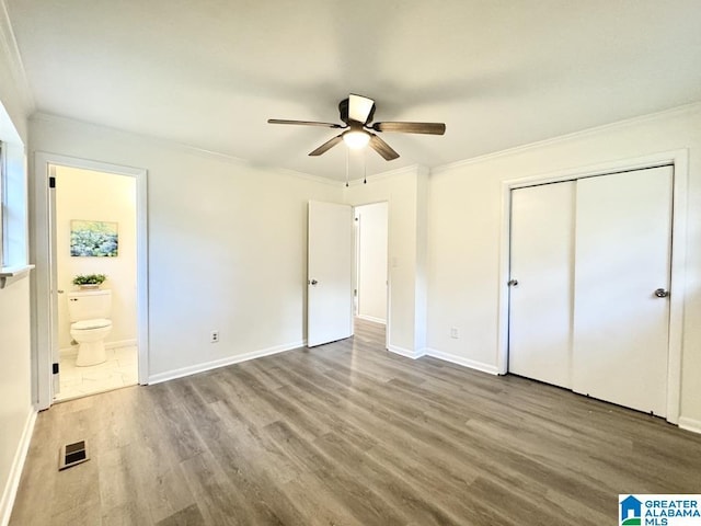 2723 6th St NE, Center Point, AL 35215 - unfurnished bedroom featuring wood finished floors, crown molding, baseboards, a closet, and connected bathroom