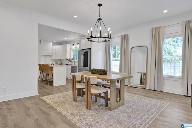 1505 36th St N, Birmingham, AL 35234 - dining area with healthy amount of natural light, a chandelier, light wood-style floors, crown molding, and baseboards
