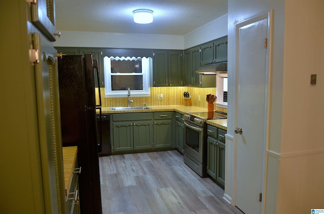 1679 Curry Hwy, Jasper, AL 35503 - kitchen featuring a sink, black appliances, green cabinets, under cabinet range hood, and light wood finished floors