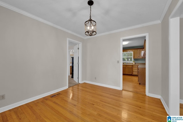1416 11th St SE, Cullman, AL 35055 - unfurnished dining area featuring light wood finished floors, a chandelier, baseboards, ornamental molding, and a sink