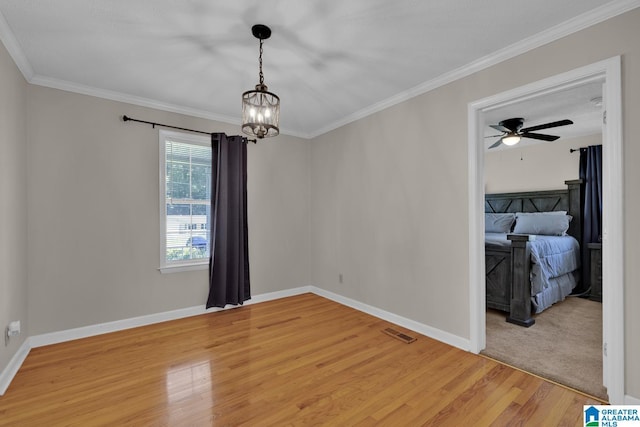 1416 11th St SE, Cullman, AL 35055 - empty room featuring a chandelier, light wood-style flooring, ornamental molding, baseboards, and a ceiling fan