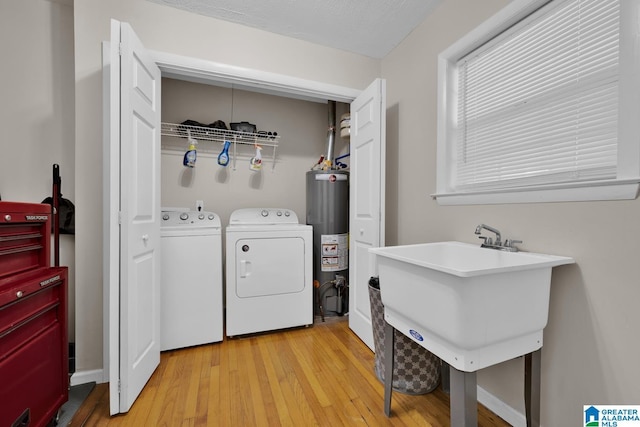 1416 11th St SE, Cullman, AL 35055 - laundry area with gas water heater, light wood finished floors, and washing machine and clothes dryer