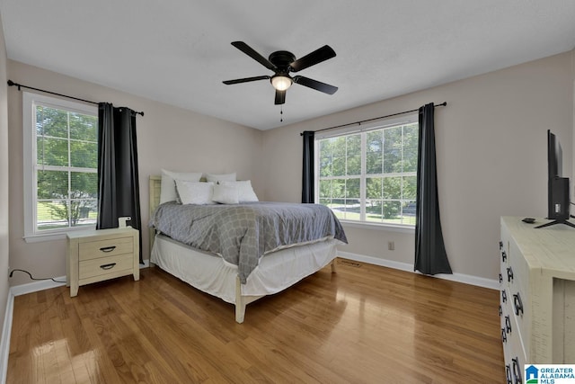 1416 11th St SE, Cullman, AL 35055 - bedroom with wood finished floors, multiple windows, and baseboards