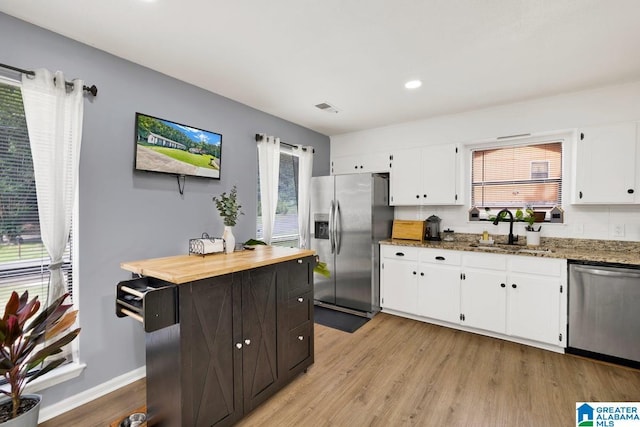 717 Country View Ter, Birmingham, AL 35215 - kitchen with stainless steel appliances, a sink, white cabinetry, light wood finished floors, and light stone countertops