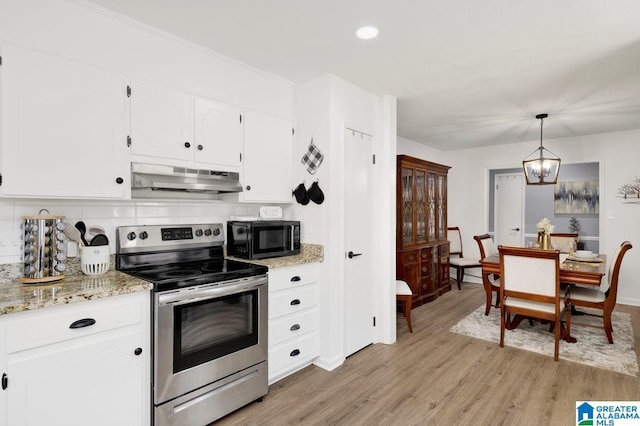 717 Country View Ter, Birmingham, AL 35215 - kitchen with electric stove, under cabinet range hood, black microwave, light wood-style floors, and backsplash