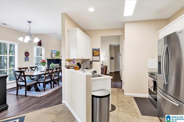 2093 Forest Lakes Ln, Sterrett, AL 35147 - kitchen with appliances with stainless steel finishes, white cabinetry, a chandelier, baseboards, and decorative light fixtures