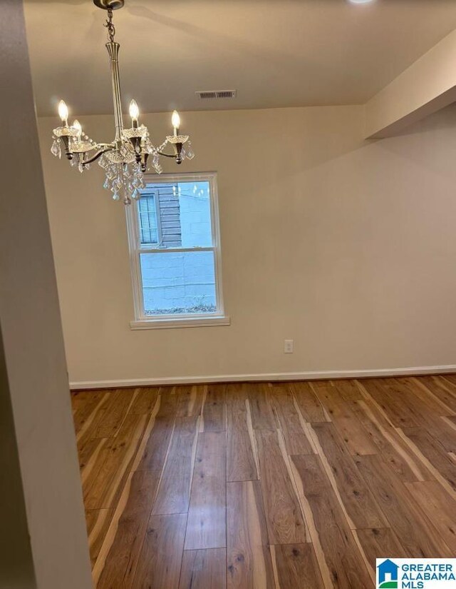 1861 Woodland Ave SW, Birmingham, AL 35211 - spare room with a chandelier, hardwood / wood-style flooring, and baseboards