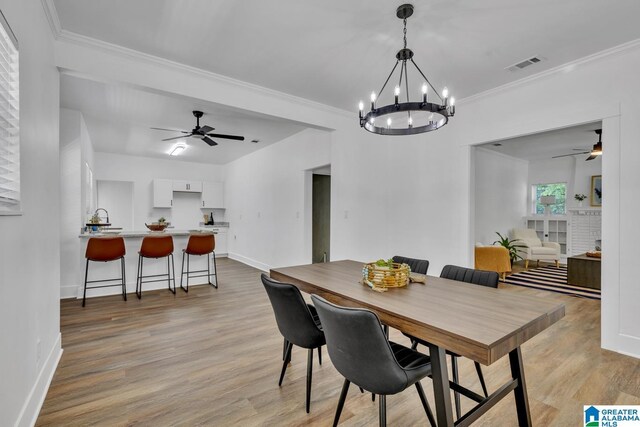 1119 8th Ave W, Birmingham, AL 35204 - dining space with a ceiling fan, light wood finished floors, baseboards, ornamental molding, and a chandelier