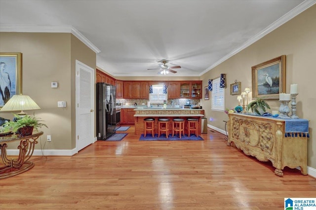 617 Golden Eagle Cir, Jasper, AL 35504 - kitchen with light countertops, black fridge with ice dispenser, a ceiling fan, a breakfast bar, and light wood finished floors