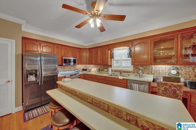 617 Golden Eagle Cir, Jasper, AL 35504 - kitchen with appliances with stainless steel finishes, a kitchen bar, a sink, light countertops, and brown cabinets
