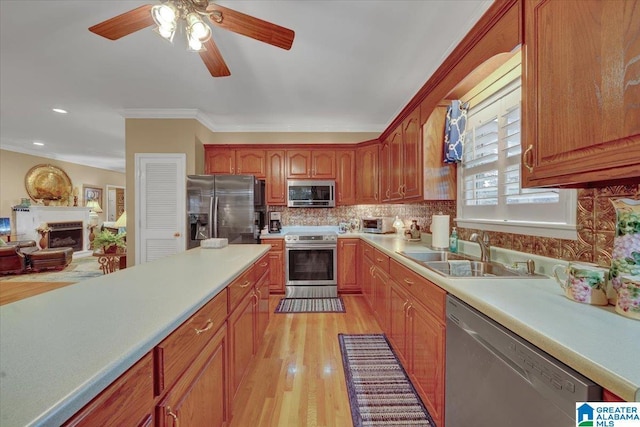 617 Golden Eagle Cir, Jasper, AL 35504 - kitchen featuring stainless steel appliances, a sink, a ceiling fan, a fireplace, and light countertops