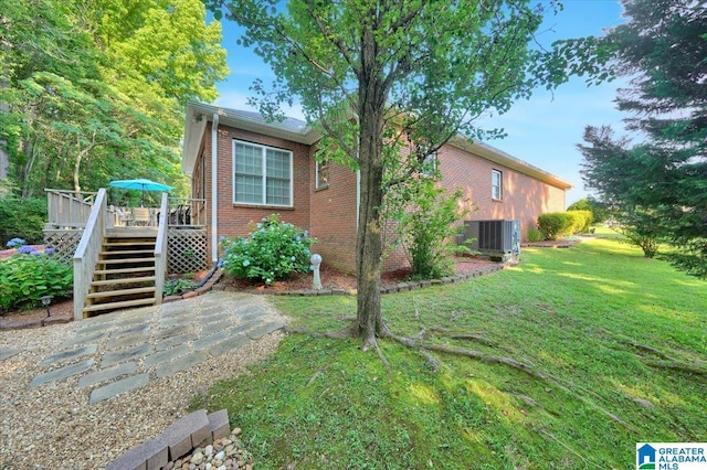617 Golden Eagle Cir, Jasper, AL 35504 - view of side of home featuring central AC unit, stairs, a deck, brick siding, and a yard